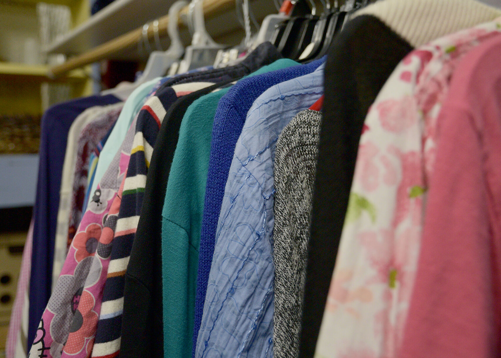 Clothes hang on racks in one of Christine DeLong's booths